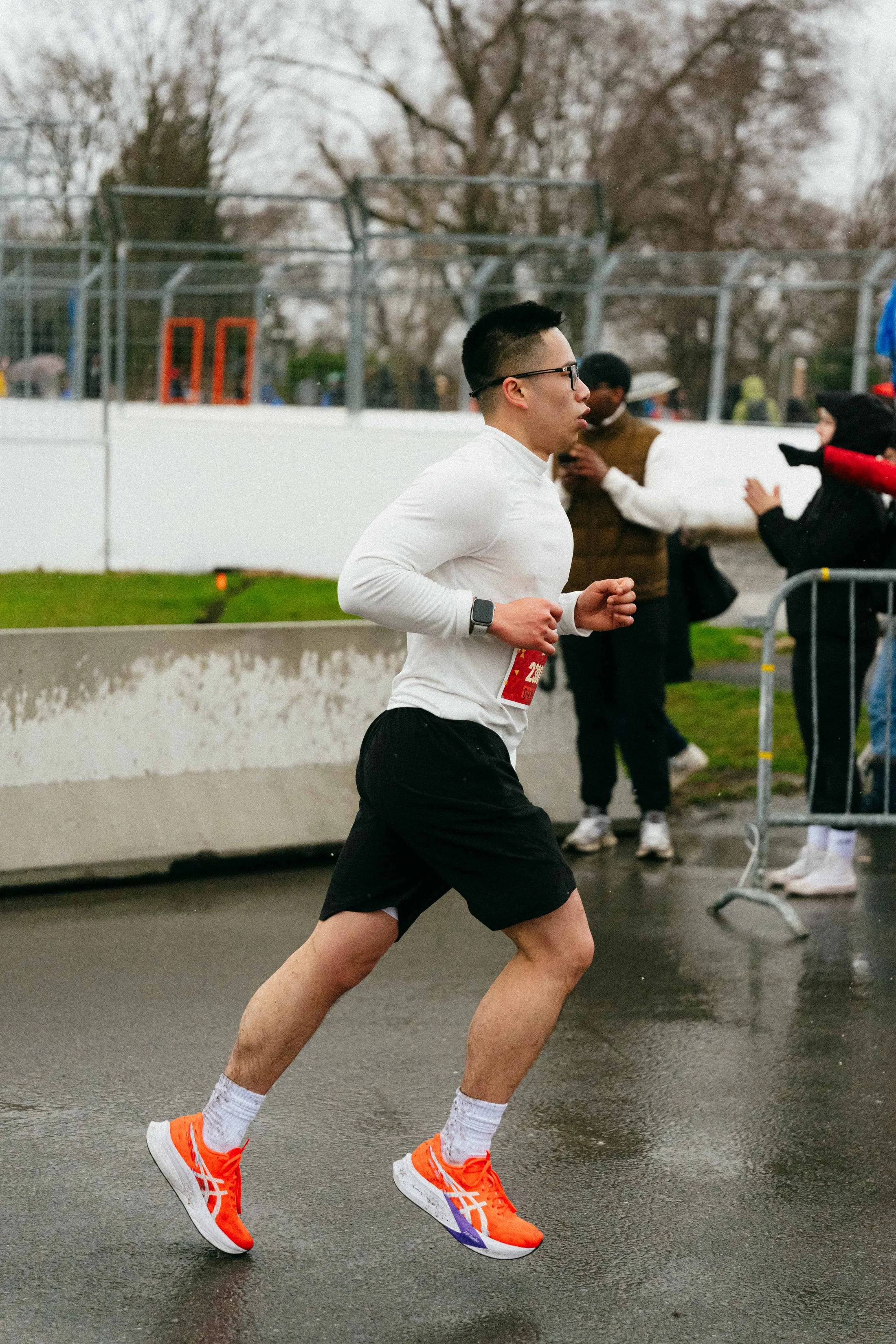 Running a half marathon in the rain, mid-stride, race bib on